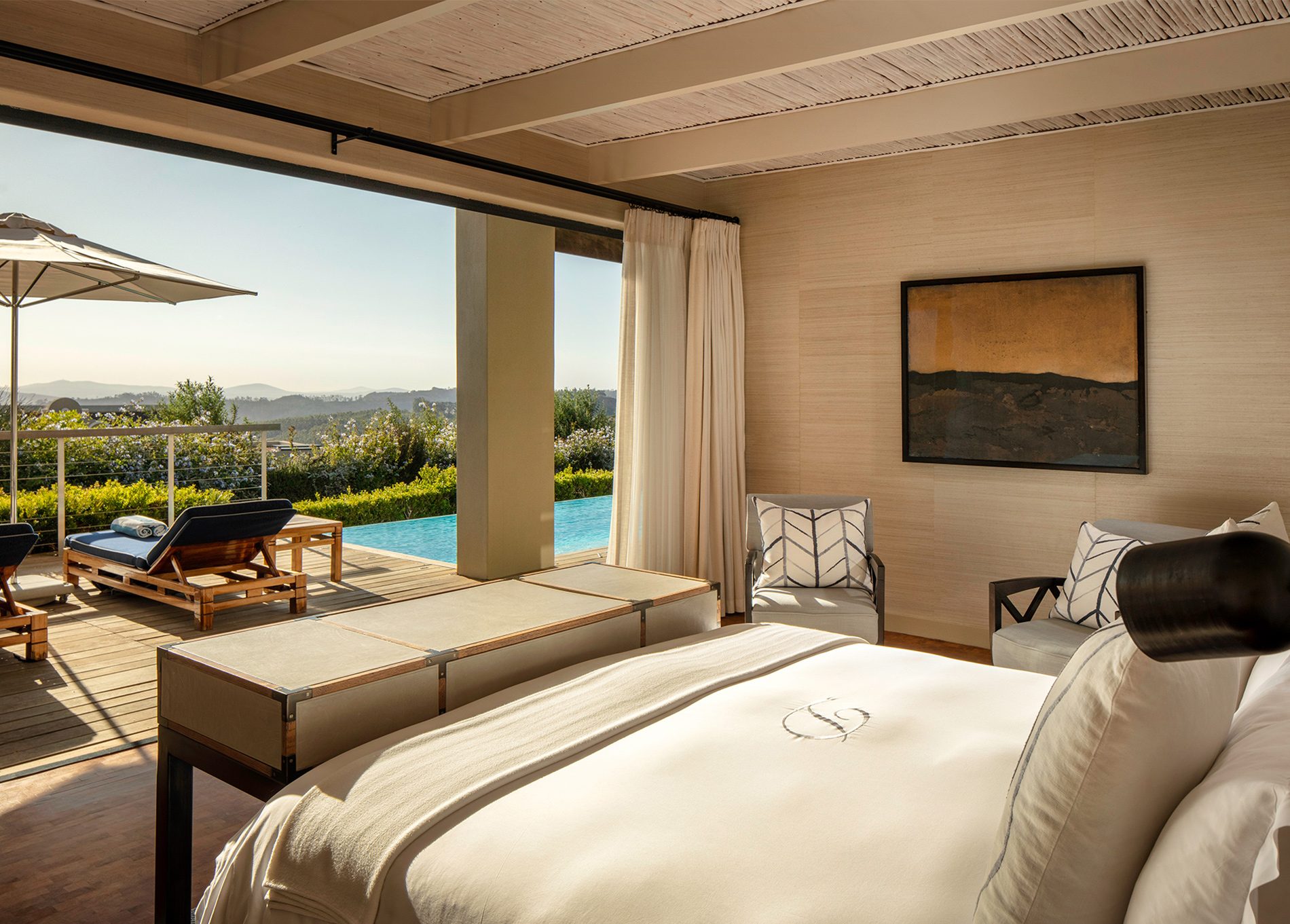 The bedroom of Delaire Graff Estate Presidential Lodge 1 leading onto private terrace with pool