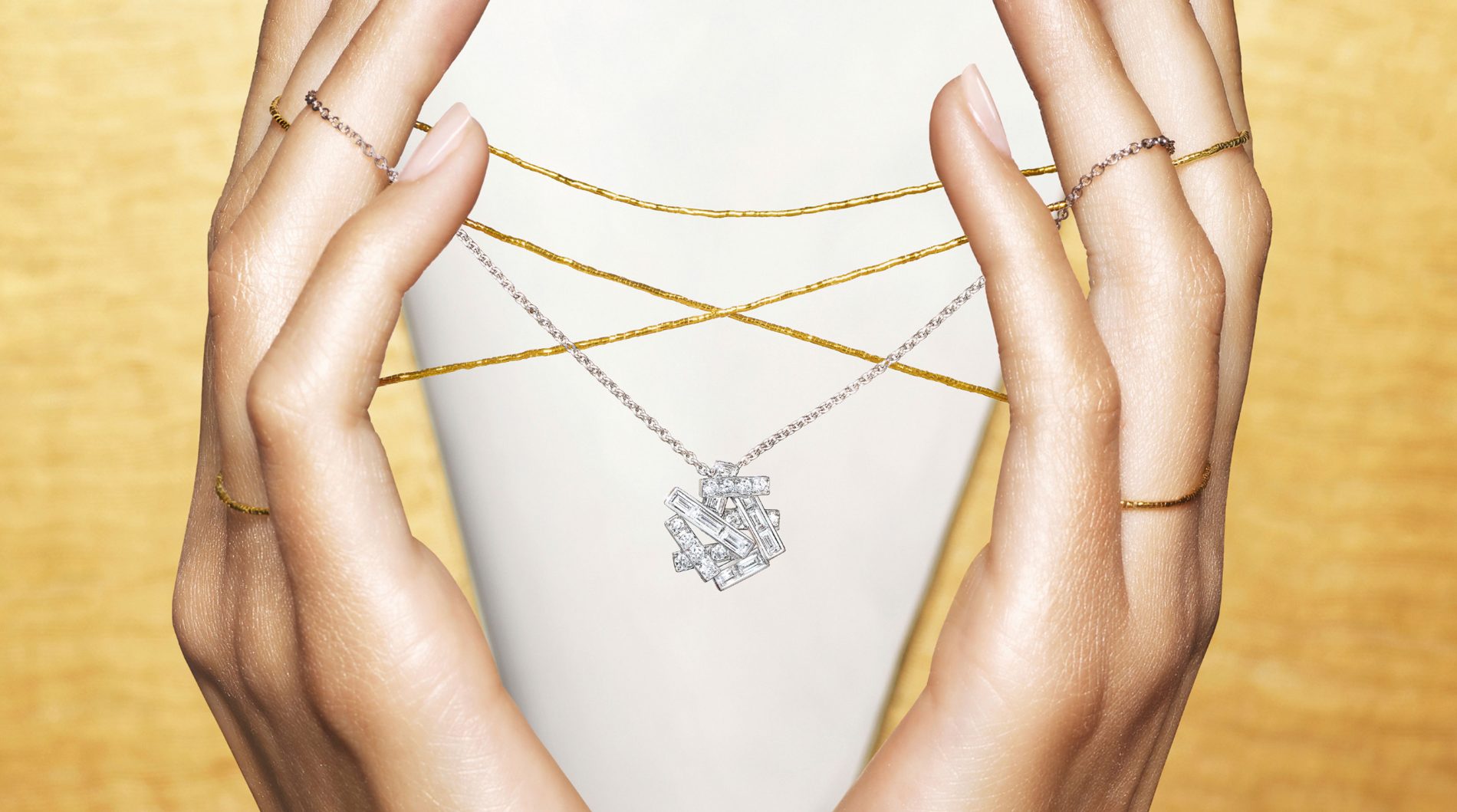 A lady holding a Graff Threads pendant