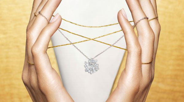 A lady holding a Graff Threads pendant
