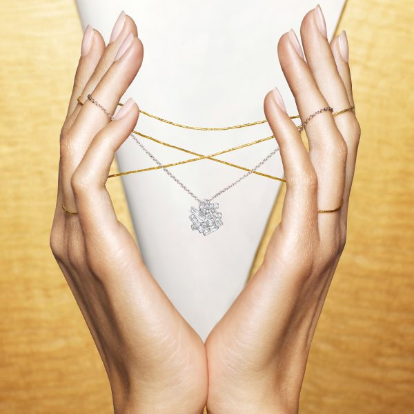 A lady holding a Graff Threads pendant