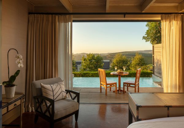 View from a Luxury Lodge bedroom leading onto terrace and pool with views across Stellenbosch vineyards