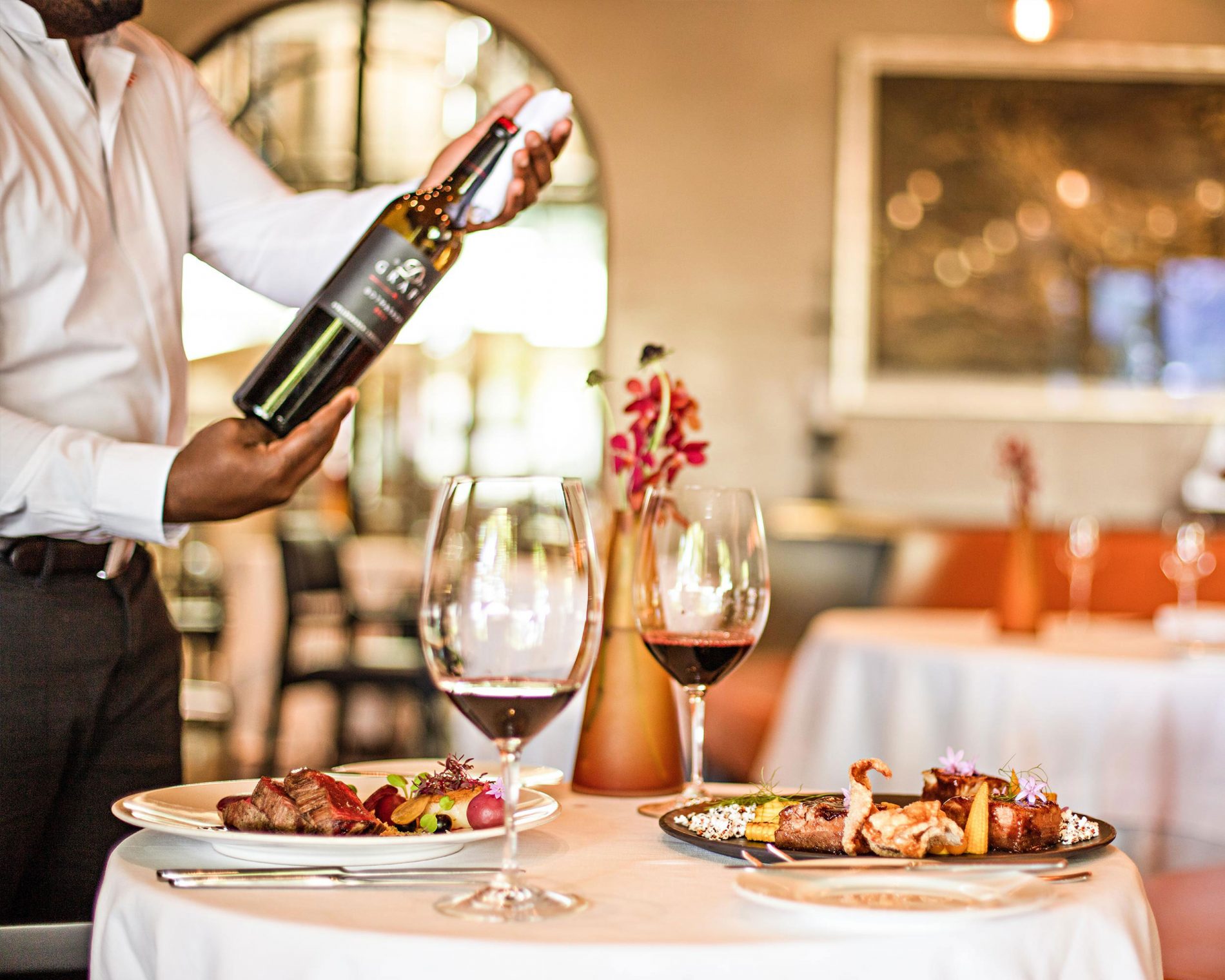 A Waiter pouring wine at Delaire Graff Restaurant