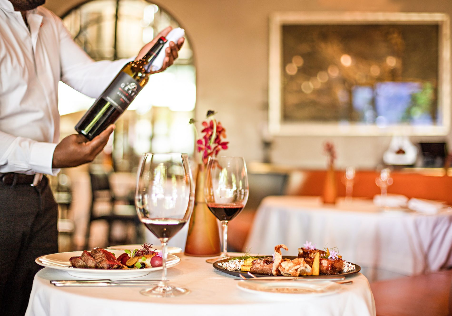 A waiter serving wine at Delaire Graff Restaurant