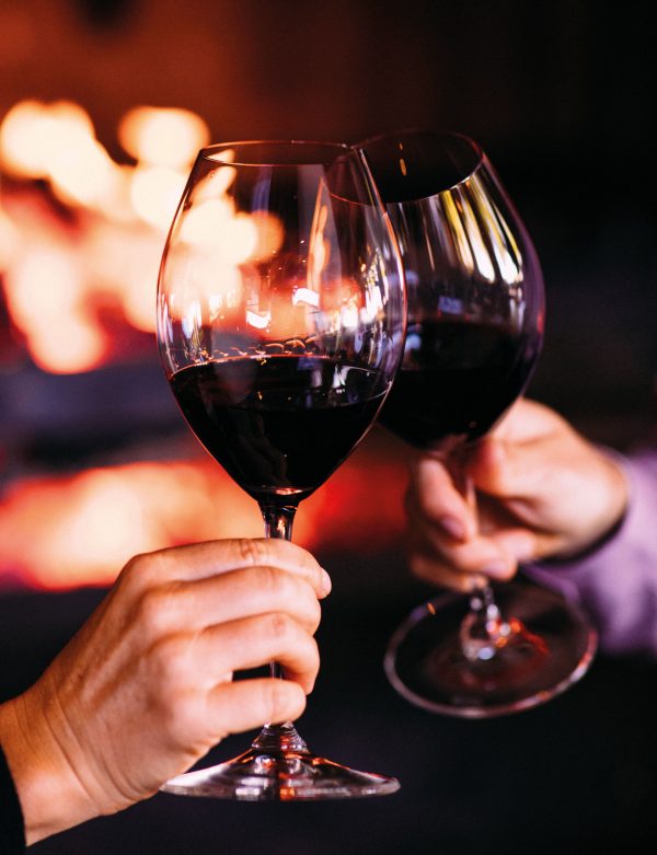 Two people raising a toast with wine glasses