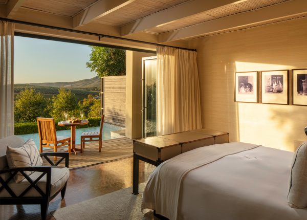 Luxury Lodge bedroom leading onto terrace and pool at Delaire Graff Estate