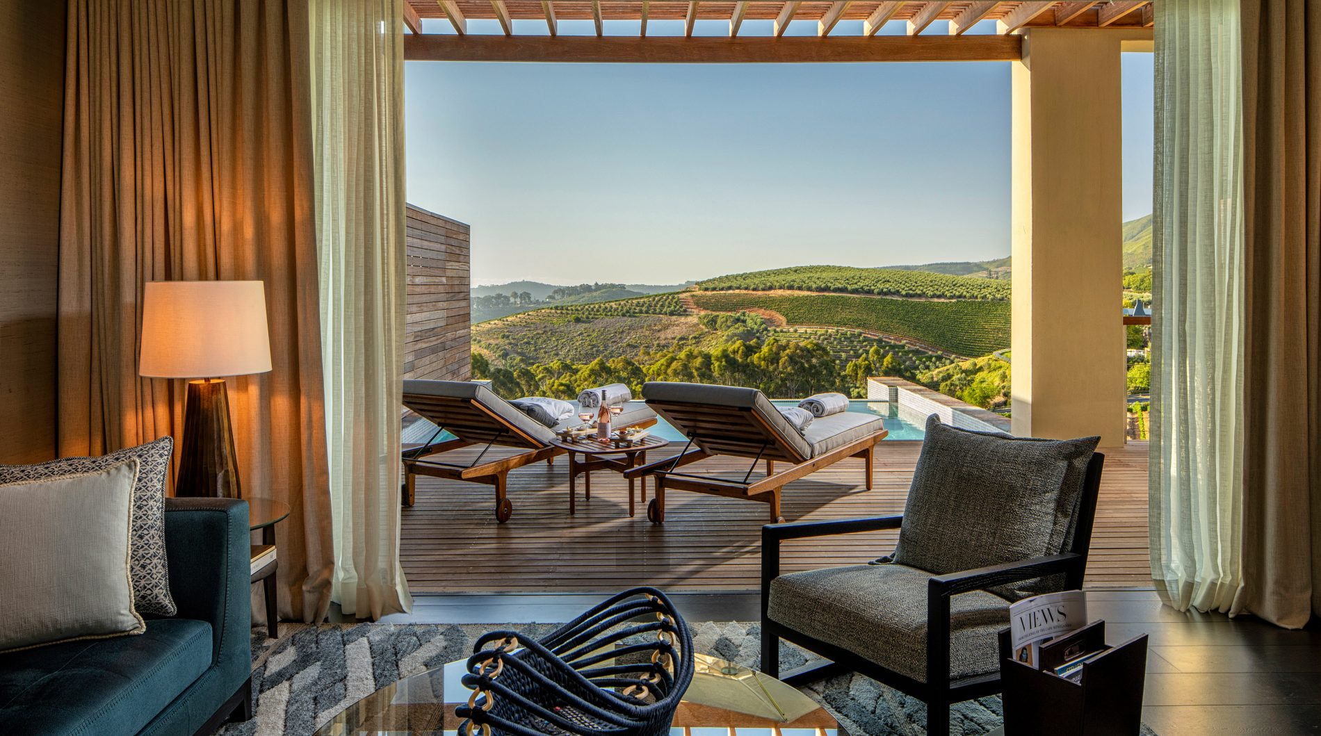 View a Superior Lodge living room towards terrace and plunge pool at Delaire Graff Estate