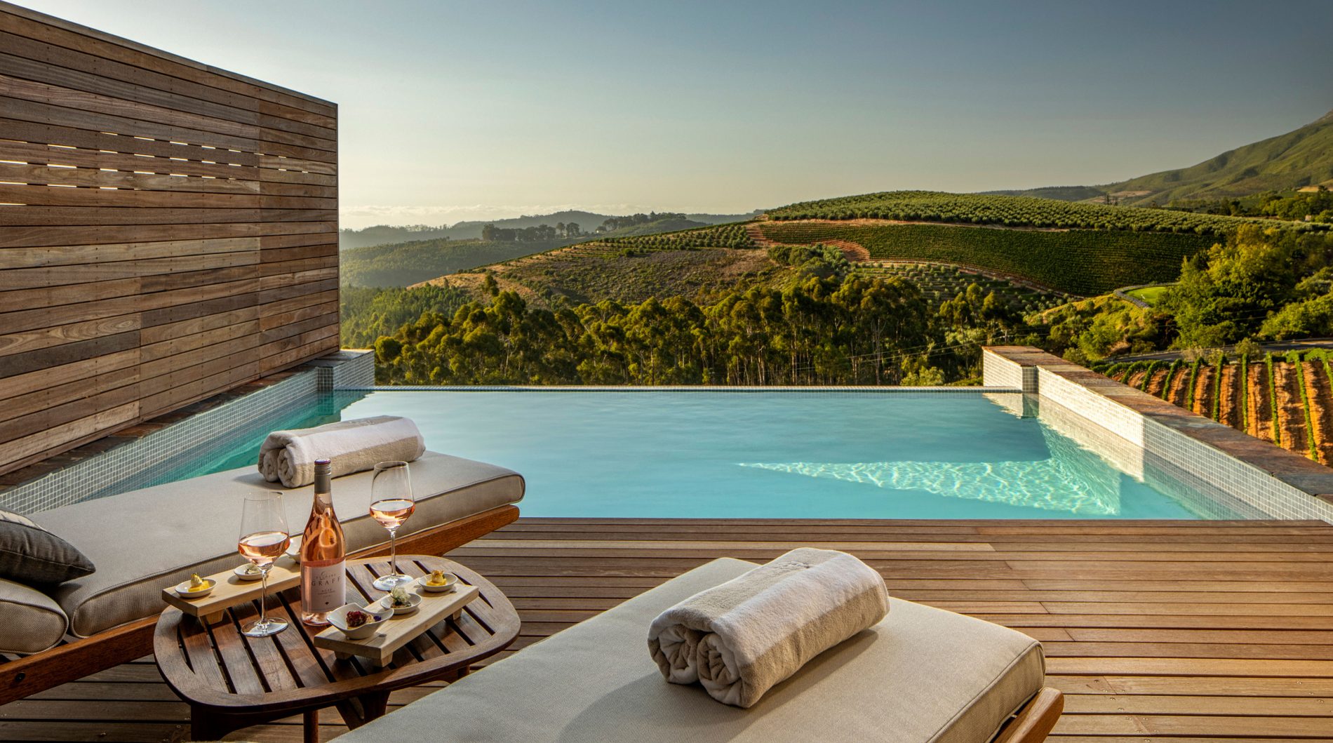 View towards Fasle Bay and Stellenbosch vineyards from a Superior Lodge Terrace with pool at Delaire Graff Estate