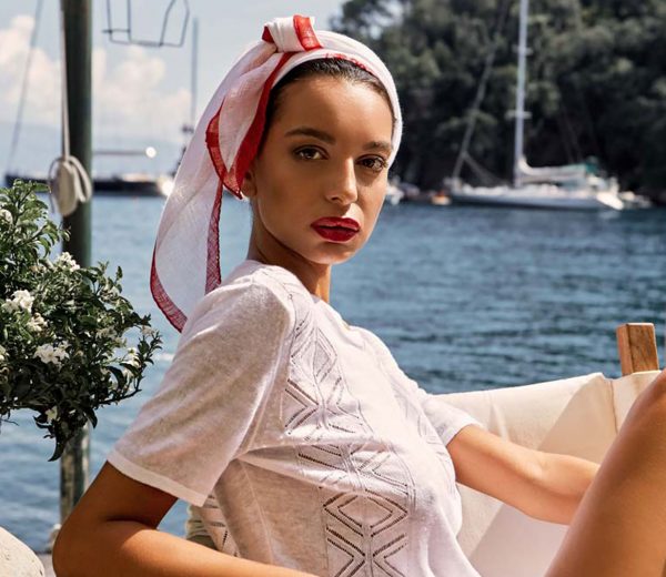 a lady wearing white linen blouse and a red and white head shawl from 100% Capri