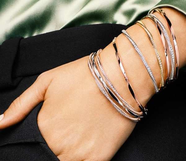 a lady wearing a stack of Graff Spiral collection diamond bangles