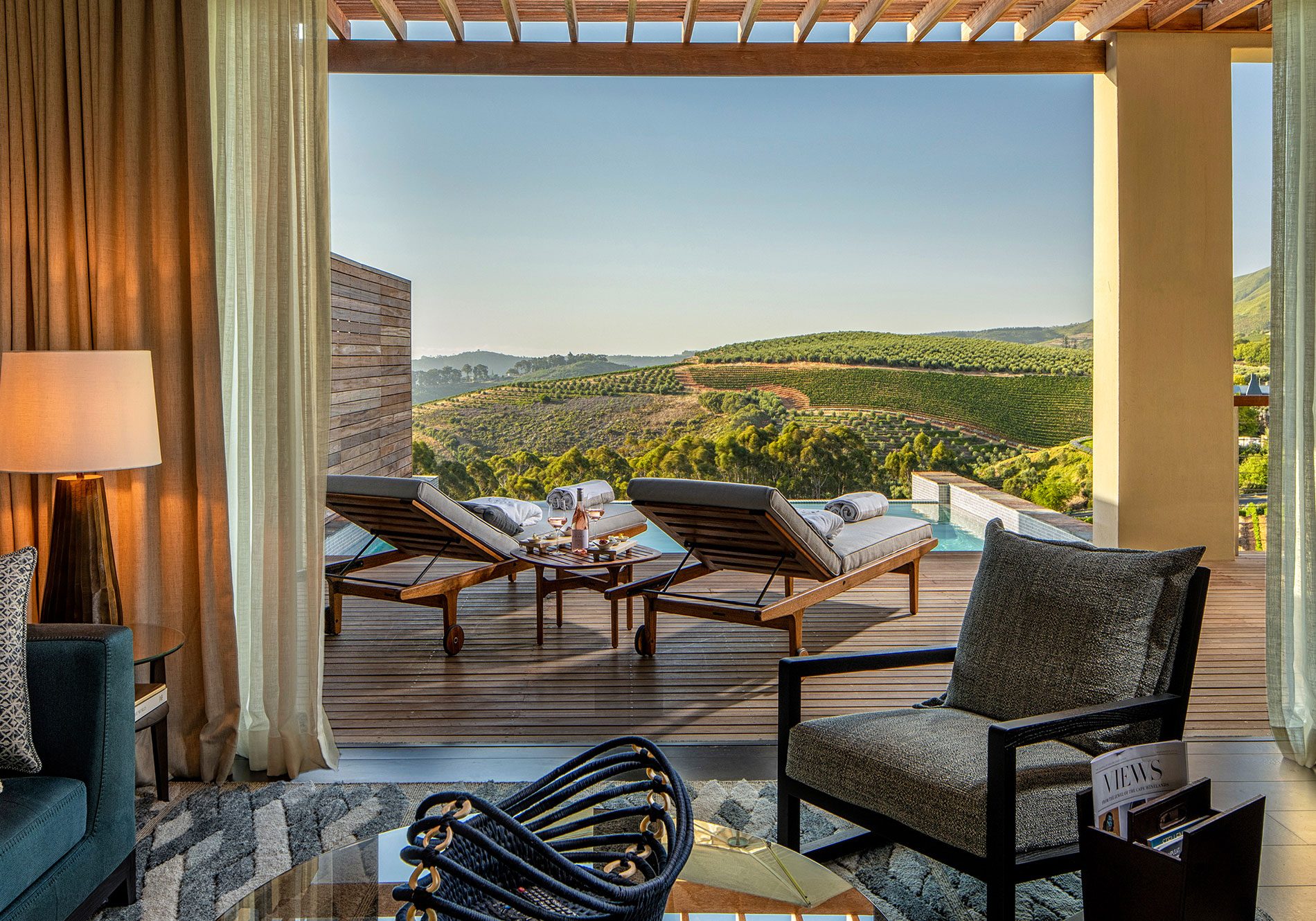 a superior lodge living room at Delaire Graff Estate leading onto terrace and private plunge pool with views over Stellenbosch vineyards