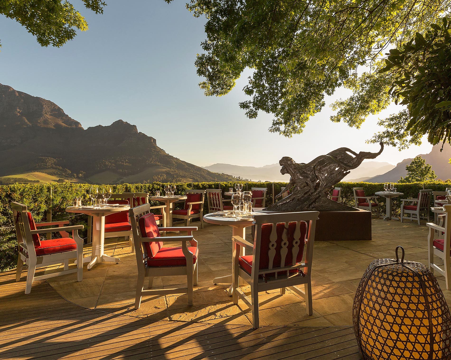 The Delaire Graff Restaurant terrace with dining tables and a Cheetah sculpture by Dylan Lewis