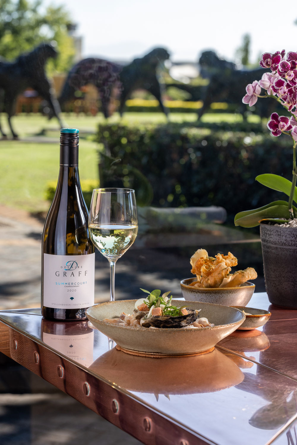 Indochine food and wine pairing with view of Delaire Graff Estate in the background